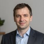 Портрет уверенного российского бизнесмена с дружелюбным взглядом на размытом нейтральном фоне студии