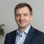 Портрет уверенного российского бизнесмена с дружелюбным взглядом на размытом нейтральном фоне студии